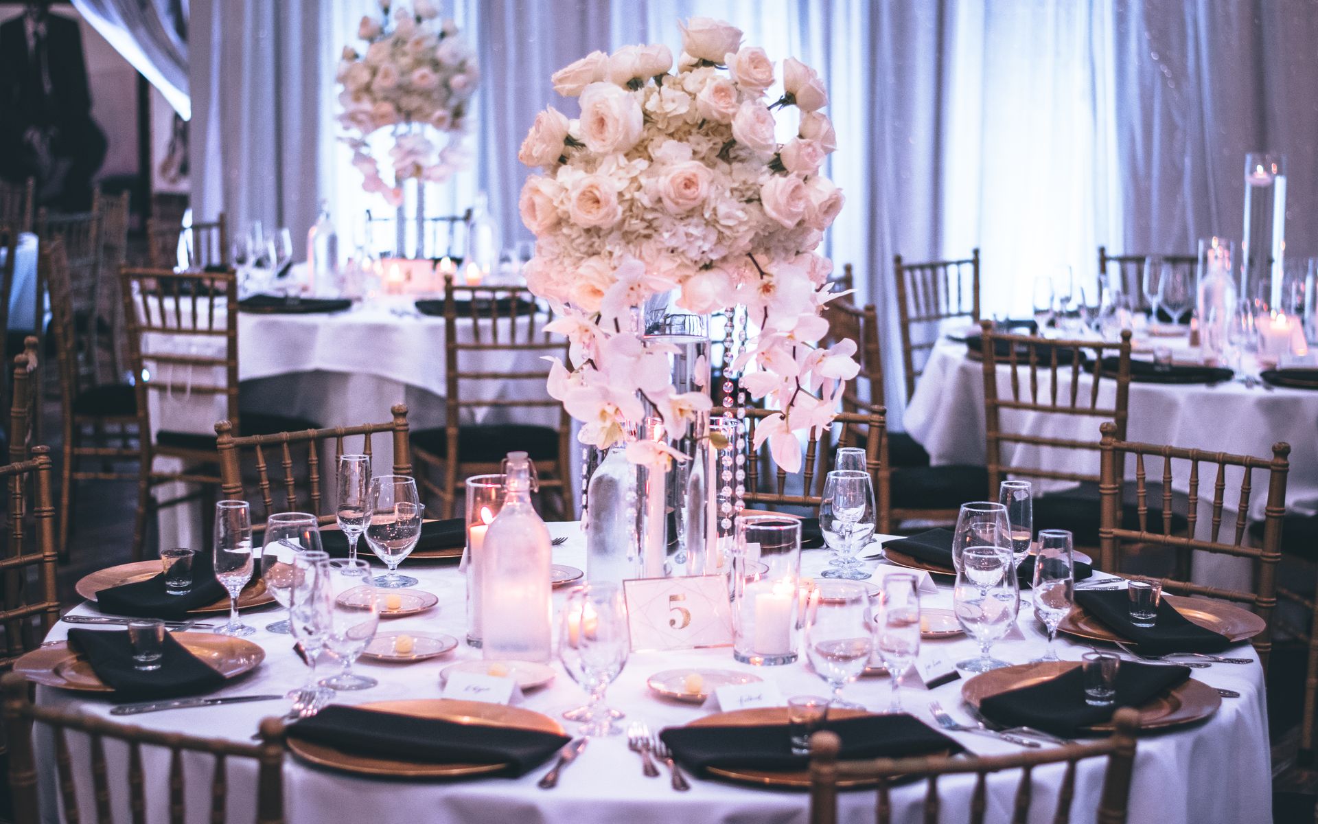 Elegant gedeckte Eventtafel mit weißen Rosen und festlicher Dekoration